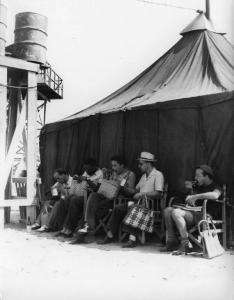 Set del film "Senza pietà" - Regia Alberto Lattuada - 1948 - Il regista Alberto Lattuada, l'attore John Kitzmiller e alcuni operatori della troupe in pausa pranzo