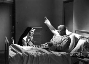 Scena del film "Anna" - Regia Alberto Lattuada - 1951 - L'attore Emilio Petacci in ospedale a letto con un braccio ingessato assistito dall'attrice Silvana Mangano in veste di suora infermiera