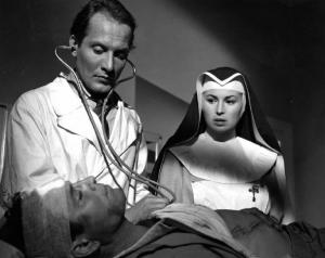 Scena del film "Anna" - Regia Alberto Lattuada - 1951 - Gli attori Piero Lulli, in camice bianco, e Silvana Mangano, in abito da suora infermiera, assistono Raf Vallone, in barella in ospedale