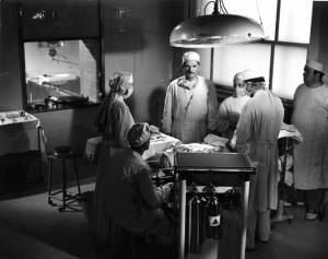 Scena del film "Anna" - Regia Alberto Lattuada - 1951 - Gli attori, Silvana Mangano, in veste di suora infermiera, Jacques Dumesnil, Piero Lulli, in camice bianco in sala operatoria con l'infermiere Mimmo Poli e altri attori non identificati