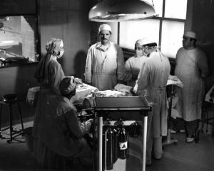 Scena del film "Anna" - Regia Alberto Lattuada - 1951 - Gli attori, Silvana Mangano, in veste di suora infermiera, Jacques Dumesnil, in camice bianco in sala operatoria con l'infermiere Mimmo Poli e altri attori non identificati