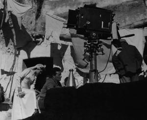 Set del film "La lupa" - Regia Alberto Lattuada - 1953 - Il regista Alberto Lattuada dietro la macchina da presa sul set con l'attrice May Britt in abito da sposa