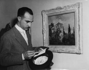 Il regista Alberto Lattuada accanto a un quadro