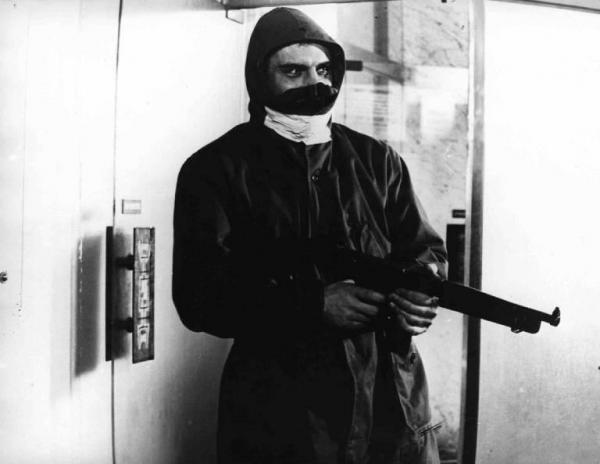 Scena del film "Banditi a Milano" - Regia Carlo Lizzani - 1968 - L'attore Gian Maria Volonté armato di mitra