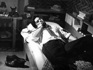 Scena dell'episodio "Agenzia matrimoniale" del film "Amore in città" - Regia Federico Fellini - 1953 - L'attore Antonio Cifariello al telefono sul letto