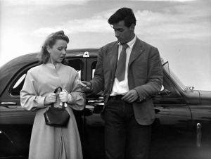 Scena dell'episodio "Agenzia matrimoniale" del film "Amore in città" - Regia Federico Fellini - 1953 - L'attore Antonio Cifariello e un'attrice non identificata appoggiati a un'automobile