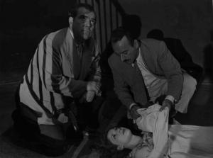 Scena del film "Amo un assassino" - Regia Baccio Baldini - 1951 - L'attore Umberto Spadaro scopre il volto a una donna stesa a terra