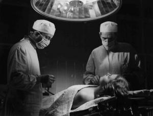 Scena del film "Anna" - Regia Alberto Lattuada - 1951 - L'attore Jacques Dumesnil, in camice bianco e mascherina, opera l'attrice Silvana Mangano, stesa sul lettino dell'ospedale