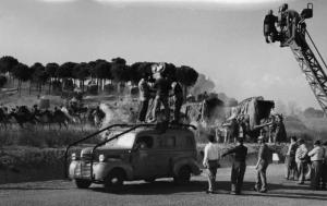 Set del film "Attila" - Regia Pietro Francisci - 1954 - Il regista Pietro Francisci dietro la macchina da presa e gli operatori della troupe durante le riprese di una scena con cavalli in corsa
