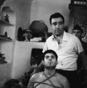 Set del film "La battaglia di Algeri" - Regia Gillo Pontecorvo - 1966 - L'operatore Marcello Gatti e un attore nonidentificato legato