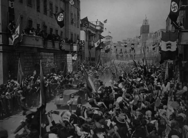 Scena del film "Bengasi" - Augusto Genina - 1942 - Corteo con pubblico festante con bardiere italiane e naziste
