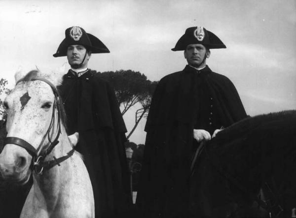 Scena del film "Il carabiniere a cavallo" - Regia Carlo Lizzani - 1961 - Gli attori Maurizio Arena e Nino Manfredi,in divisa da carabiniere, a cavallo