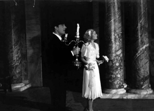 Scena del film "Castelli in aria" - Regia Augusto Genina - 1939 - Gli attori Vittorio De Sica, con un candelabro, e Lilian Harvey