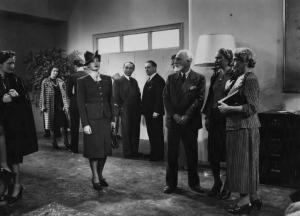 Scena del film "Chi sei tu?" - Regia Gino Valori - 1939 - L'attrice Maria Denis in piedi e altri attori non identificati in una stanza