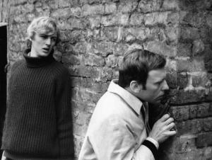 Scena del film "Col cuore in gola" - Regia Tinto Brass - 1967 - Gli attori Charles Kohler e Jean-Louis Trintignant dietro a un muro