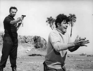 Scena del film "Come rubammo la bomba atomica" - Regia Lucio Fulci - 1967 - Un attore non identificato punta la pistola all'attore Franco Franchi