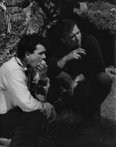 Scena del film "La commare secca" - Regia Bernardo Bertolucci - 1962 - L'attore Francesco Ruiu e l'attore Giacarlo De Rosa accovacciati.