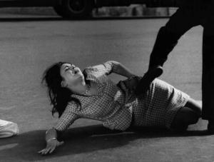 Scena del film "La commare secca" - Regia Bernardo Bertolucci - 1962 - L'attrice Gabriella Giorgelli a terra mentre le viene dato un calcio.