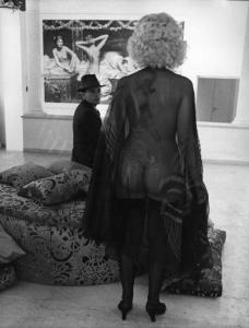 Scena del film "Il Conformista" - Regia Bernardo Bertolucci - 1970 - L'attore Jean-Louis Trintignant, seduto, osserva un'attrice non identificata, nuda, in piedi davanti a lui