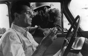 Scena del film "Congo vivo" - Regia Giuseppe Bennati - 1961- L'attore Gabriele Ferzetti, in auto, maneggia delle banconote mentre un soldato lo guarda