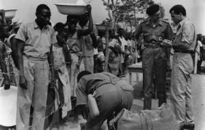 Scena del film "Congo vivo" - Regia Giuseppe Bennati - 1961- Attori non identificati in fila attendono la loro razione di cibo mentre l'attore Gabriele Ferzetti parla con un membro della Croce Rossa