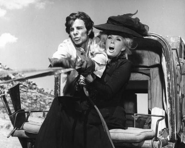Fotografia del film "I crudeli" - Regia Sergio Corbucci 1967 - L'attore Julian Mateos prende le redini della carrozza su cui siede anche l'attrice Maria Martin.