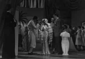 Scena del film "Contessa di Parma" - Regia Alessandro Blasetti - 1937 - L'attrice Elisa Cegani, al centro di una stanza, festeggia con alcuni attori non identificati al suo fianco