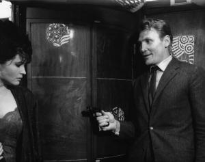 Set del film "Il criminale" - Regia Marcello Baldi- 1962 - L'attrice Yvonne Furneaux minacciata con una pistola dall'attore Jack Palance.