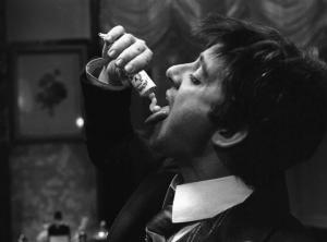 Fotografia del film "Cuore di cane" - Regia Alberto Lattuada 1976 - L'attore Cochi Ponzoni si spreme un tubetto di pasta dentifricia sulla lingua.