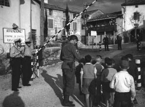 Fotografia del film "Cuori senza frontiere" - Regia Luigi Zampa 1950 - Un attore non identificato guida dei bambini oltre una barriera
.