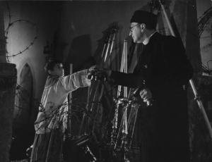 Fotografia del film "Cuori senza frontiere" - Regia Luigi Zampa 1950 - Un bambino porge delle campanelle all'attore Gino Cavalieri in vesti sacerdotali.