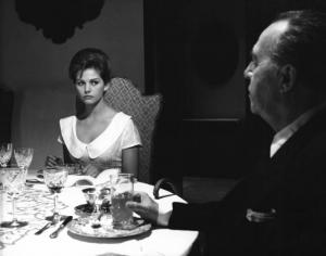 Fotografia del film "I delfini" - Regia Francesco Maselli 1960 - L'attrice Claudia Cardinale seduta a tavola con un attore non identificato.