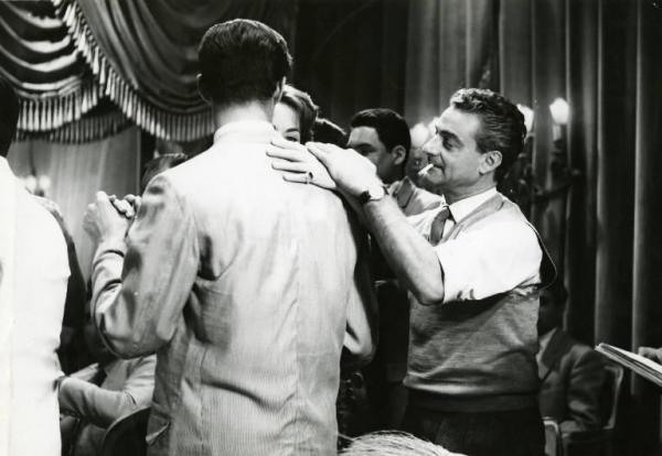 Sul set del film "La diga sul Pacifico" - Regia René Clément, 1957 - Anthony Perkins, di schiena, balla con Alida Valli di cui si scorge una parte del volto. René Clément, tenendo una sigaretta in bocca, corregge la loro postura.