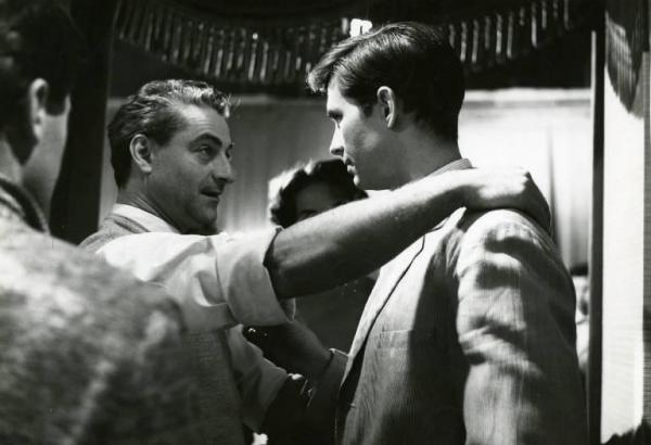 Sul set del film "La diga sul Pacifico" - Regia René Clément, 1957 - René Clement, appoggia una mano sulla spalla di Anthony Perkins. Dietro di loro, si intravede Alida Valli. In primo piano, di spalle, un attore non identificato.