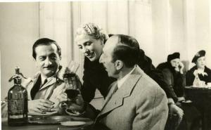Sul set del film "Il destino in tasca" - Regia Gennaro Righelli, 1938 - Enrico Viarisio e Claudio Ermelli offrono da bere a Rita Livesi durante le riprese del film.