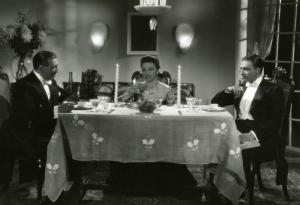 Scena del film "Diamanti" - Regia Corrado D'Errico, 1939 - Totale: Doris Duranti, al centro, tra Guglielmo Sinaz, a sinistra, e Enrico Glori, a destra, seduti a tavola.