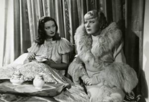 Scena del film "Diamanti" - Regia Corrado D'Errico, 1939 - Totale: Doris Duranti, a sinistra, e Gemma Bolognesi, a destra, sedute sul letto mentre dialogano. Doris Duranti tiene in mano una tazza da tè.