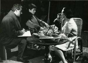 Sul set del film "La diga sul Pacifico" - Regia René Clément, 1957 - Intorno a un tavolino sono seduti, da sinistra, il regista René Clément, con taccuino e matita, Anthony Perkins, un attore non identificato e Yvonne Sanson.