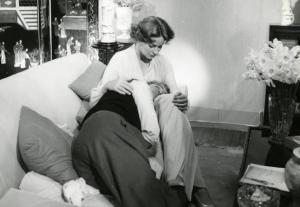 Sul set del film "La diga sul Pacifico" - Regia René Clément, 1957 - Il regista René Clément, semisdraiato su un divano, appoggia la testa sul grembo di Alida Valli seduta accanto al bracciolo. I due si guardano.