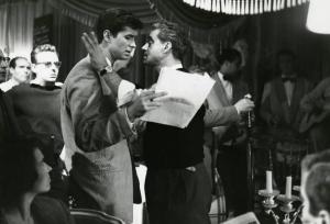 Sul set del film "La diga sul Pacifico" - Regia René Clément, 1957 - Anthony Perkins e René Clément, in piedi, uno di fronte all'altro. Il regista, istruisce l'attore mentre legge il copione. Attorno a loro attori non identificati.
