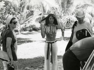 Sul set del film "Il dio serpente" - Regia Piero Vivarelli, 1970 - Nadia Cassini, si spazzola i capelli. Attorno a lei persone della troupe. Sullo sfondo, palme caraibiche.
