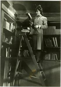 Scena del film "Divieto di sosta" - Regia Marcello Albani, 1941 - Rubi Dalma in piedi su una scala a pioli mentre legge un libro.