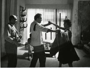 Sul set del film "La dolce vita" - Regia Federico Fellini, 1960 - Piano americano di Federico Fellini che balla con Nadia Gray. A sinistra, Mino Doro, li guarda. Sullo sfondo, una donna seduta su un divanetto.