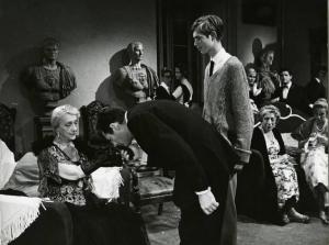 Scena del film "La dolce vita" - Regia Federico Fellini, 1960 - Marcello Mastroianni bacia la mano di Elisabetta Cini. Accanto a lui, in piedi, Ivenda Dobrzensky e sullo sfondo, altre persone, guardano.