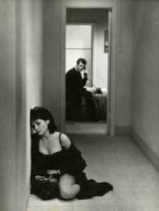Scena del film "La dolce vita" - Regia Federico Fellini, 1960 - Yvonne Furneaux, accasciata a terra, si appoggia al muro. Sullo sfondo, Marcello Mastroianni, seduto, telefona.