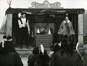 Scena del film "Un dollaro di fifa" - Regia Giorgio Simonelli, 1960 - Totale. Walter Chiari, a sinistra, e Ugo Tognazzi, a destra, recitano su un palchetto che ha come insegna "Alamo e Mike Ipnotismo e magia".