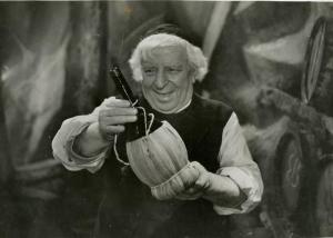 Scena del film "Don Buonaparte" - Regia Flavio Calzavara, 1941 - Mezza figura di Ermete Zacconi che tiene tra le mani un fiasco di vino che guarda sorridendo.