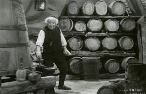 Scena del film "Don Buonaparte" - Regia Flavio Calzavara, 1941 - Figura intera di Ermete Zacconi mentre apre il rubinetto di una botte. Sullo sfondo, botti di vino.