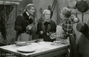 Scena del film "Don Buonaparte" - Regia Flavio Calzavara, 1941 - In una cucina intorno a un tavolo con sopra uova e farina, Osvaldo Valenti e Adele Garavaglia parlano con una donna con indosso un grembiule.