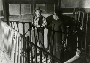 Scena del film "Don Camillo" - Regia Julien Duvivier, 1952 - In una stalla figura intera di Gino Cervi che imbraccia un fucile, mentre, Fernandel lo trattiene per un braccio.